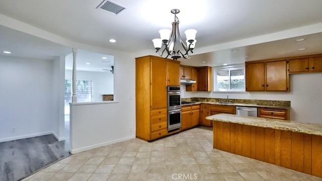 kitchen featuring stainless steel appliances, a sink, visible vents, brown cabinetry, and pendant lighting