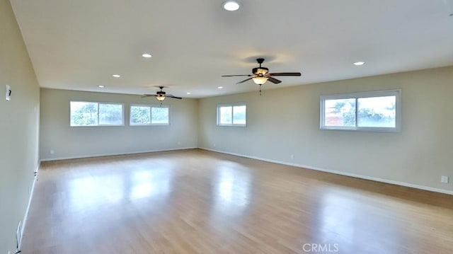 unfurnished room featuring baseboards, wood finished floors, and recessed lighting