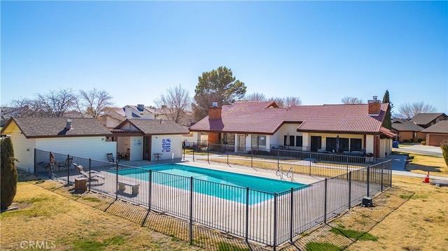 community pool featuring a yard, fence, and a patio