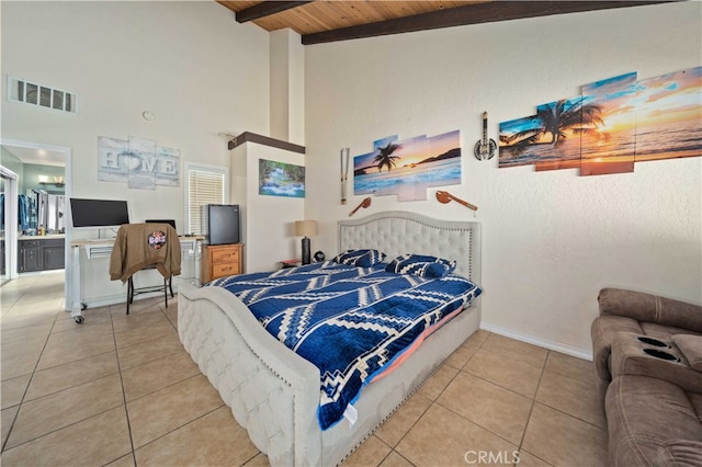 tiled bedroom with beam ceiling, visible vents, a high ceiling, wood ceiling, and baseboards