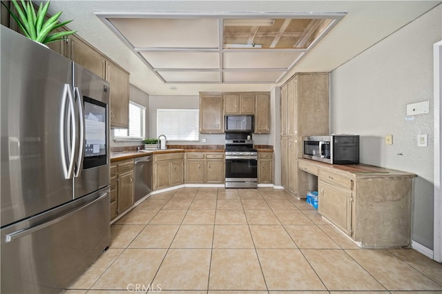 kitchen with light tile patterned floors, stainless steel appliances, and a sink