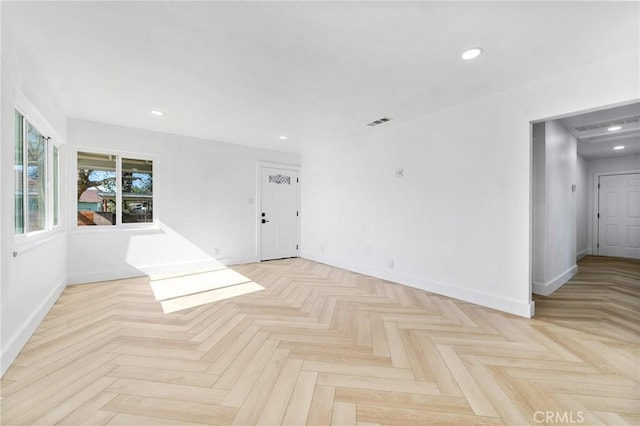 empty room featuring baseboards, visible vents, and recessed lighting