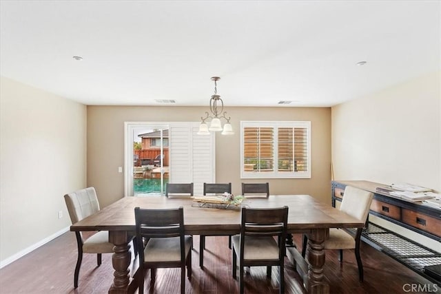 dining room featuring visible vents, plenty of natural light, baseboards, and wood finished floors