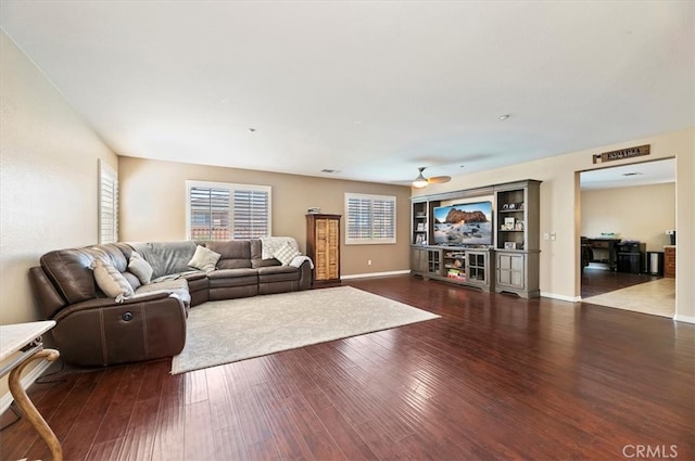 living room with ceiling fan, baseboards, and wood finished floors