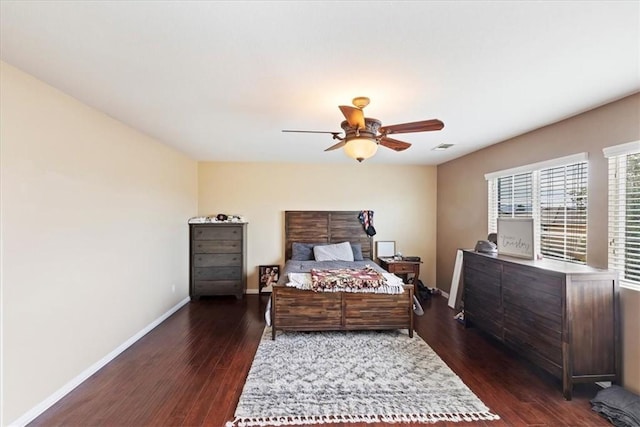 bedroom featuring dark wood-type flooring, visible vents, baseboards, and a ceiling fan