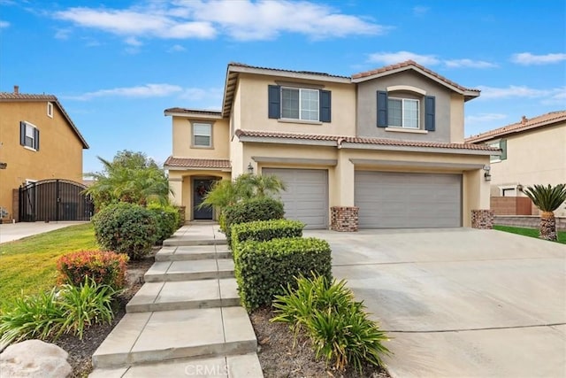 view of front of property with driveway, a tile roof, an attached garage, a gate, and stucco siding