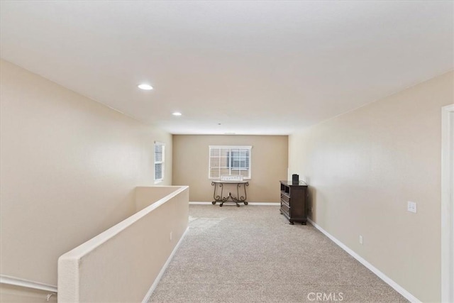 corridor with light carpet, an upstairs landing, baseboards, and recessed lighting