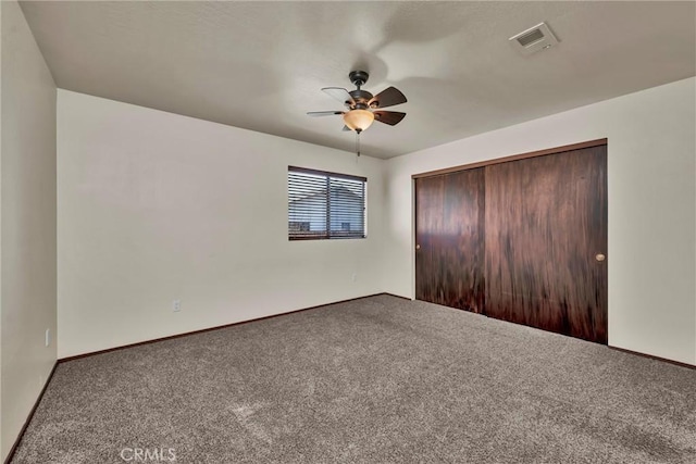 unfurnished bedroom with a ceiling fan, carpet, a closet, and visible vents