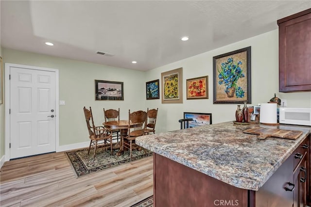 kitchen with visible vents, light wood finished floors, white microwave, and recessed lighting