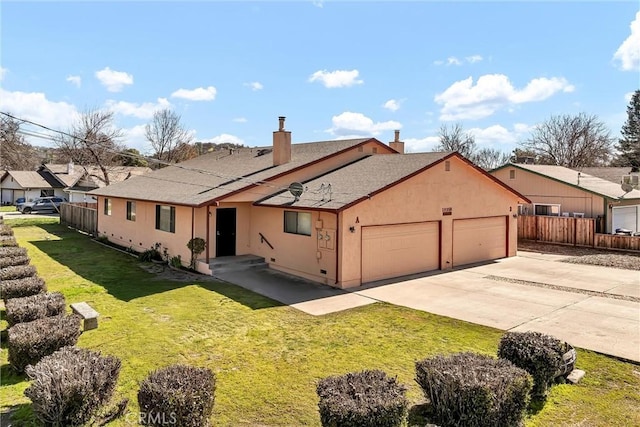 back of property with a garage, fence, concrete driveway, a yard, and stucco siding