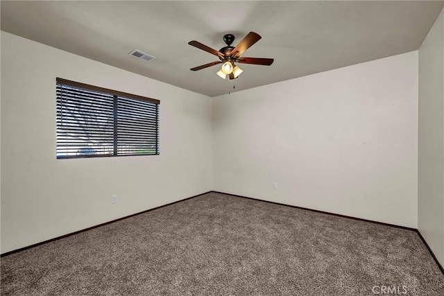 carpeted spare room featuring baseboards, visible vents, and a ceiling fan