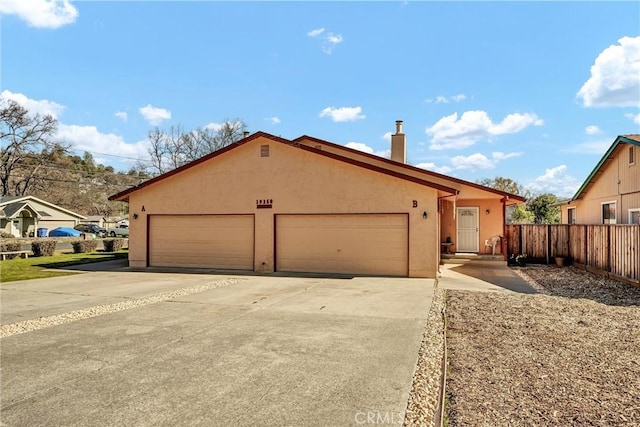 single story home featuring driveway, a chimney, an attached garage, fence, and stucco siding