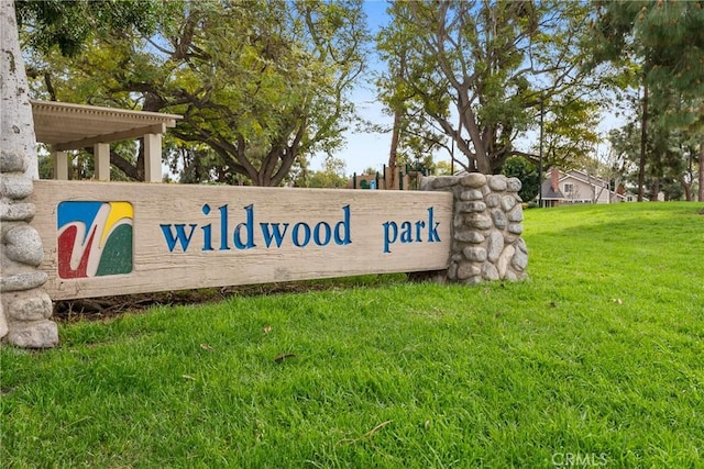 community / neighborhood sign featuring a lawn