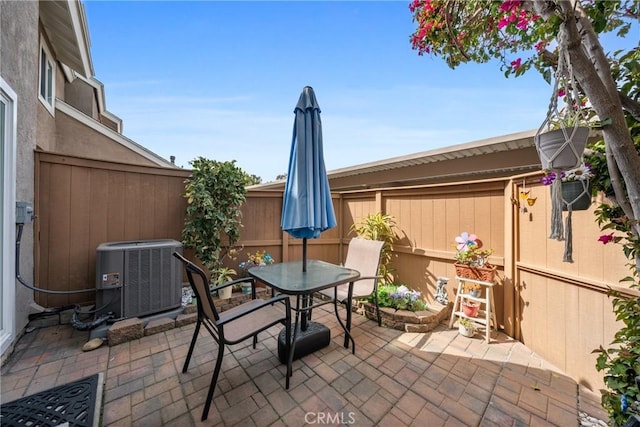 view of patio with a fenced backyard, cooling unit, and outdoor dining space