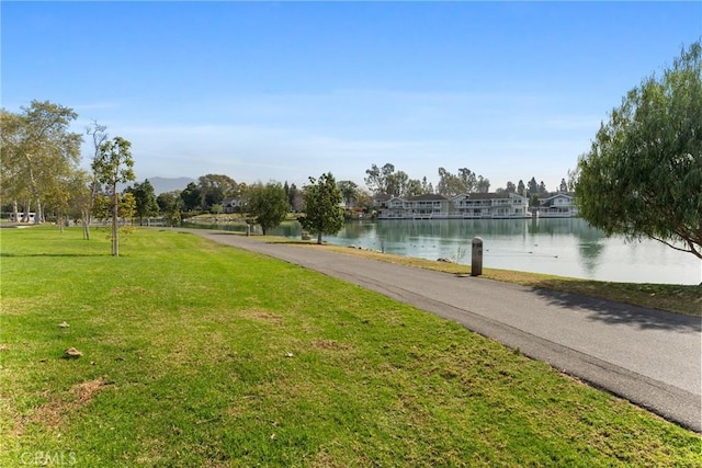 surrounding community featuring a water view and a lawn