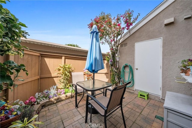 view of patio featuring outdoor dining area and fence