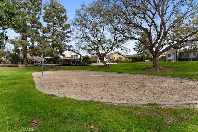 view of property's community with a lawn and volleyball court