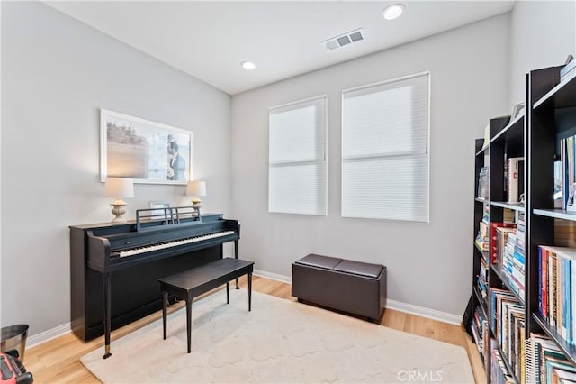 sitting room with baseboards, visible vents, wood finished floors, and recessed lighting