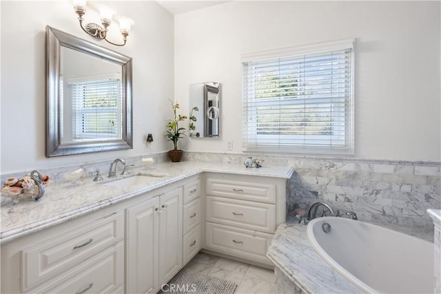 bathroom with marble finish floor, a garden tub, and vanity