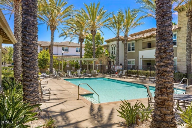 pool with fence and a patio