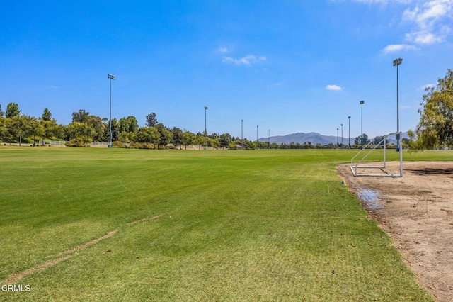 surrounding community with a yard and a mountain view