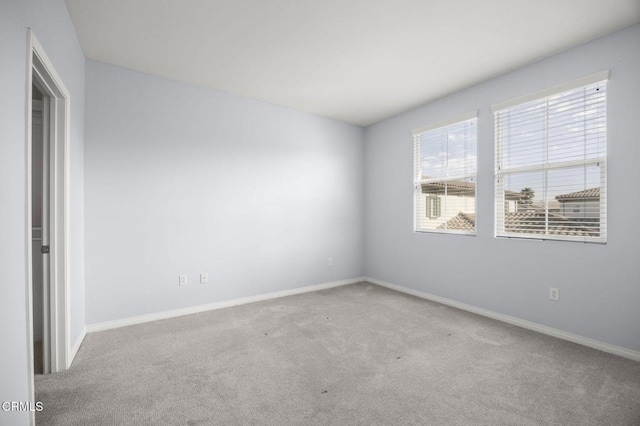 carpeted spare room with baseboards