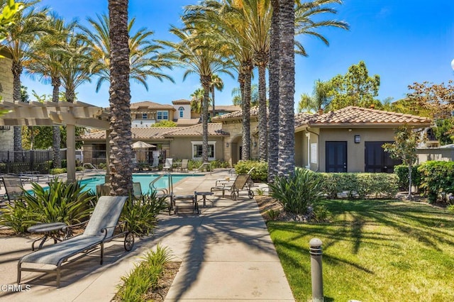 exterior space featuring a pool, a patio area, a yard, and fence