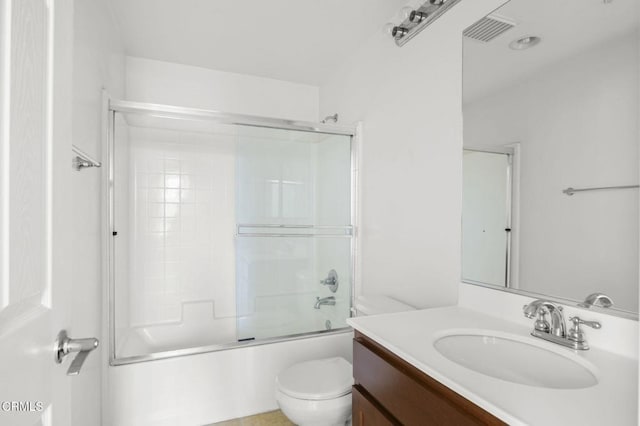 bathroom featuring toilet, visible vents, combined bath / shower with glass door, and vanity