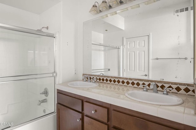 full bathroom featuring enclosed tub / shower combo, double vanity, a sink, and visible vents