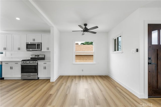 kitchen with appliances with stainless steel finishes, light countertops, white cabinetry, and light wood-style flooring