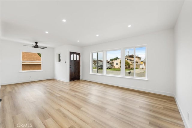 unfurnished living room with light wood-type flooring, baseboards, and recessed lighting