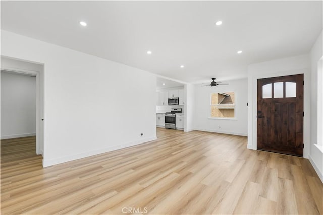 foyer with recessed lighting, ceiling fan, light wood-style flooring, and baseboards