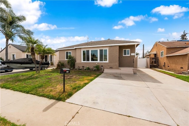 view of front of property featuring a gate, a front lawn, and brick siding