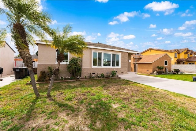 ranch-style home with driveway, stucco siding, crawl space, a front yard, and brick siding