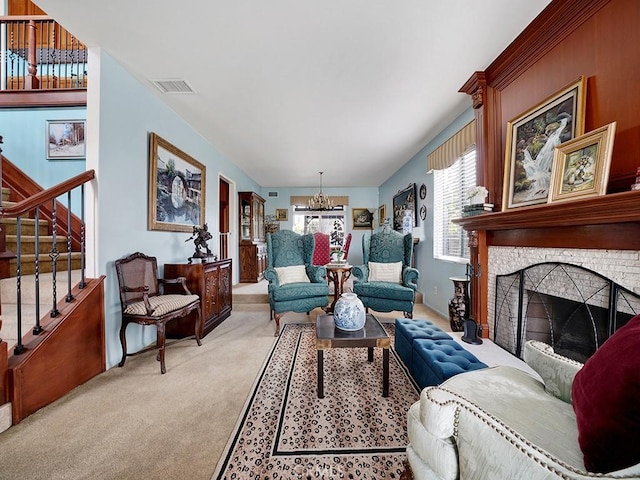 living area with visible vents, stairway, an inviting chandelier, carpet flooring, and a stone fireplace