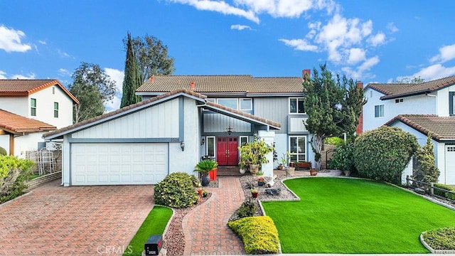 view of front of home with a garage, a front yard, decorative driveway, and a tile roof