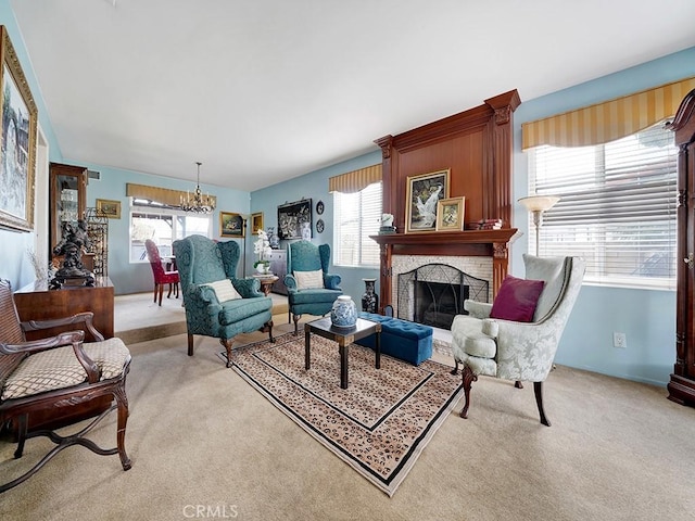 living area featuring light carpet, a healthy amount of sunlight, a fireplace, and a notable chandelier