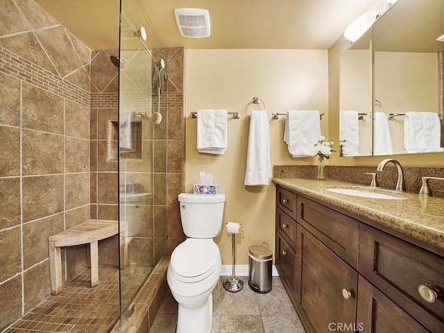 bathroom featuring visible vents, toilet, vanity, a walk in shower, and tile patterned flooring