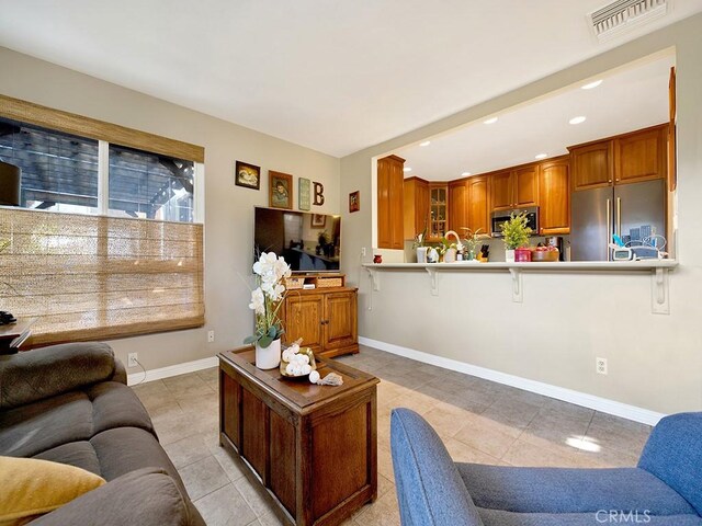 living area featuring light tile patterned floors, recessed lighting, visible vents, and baseboards