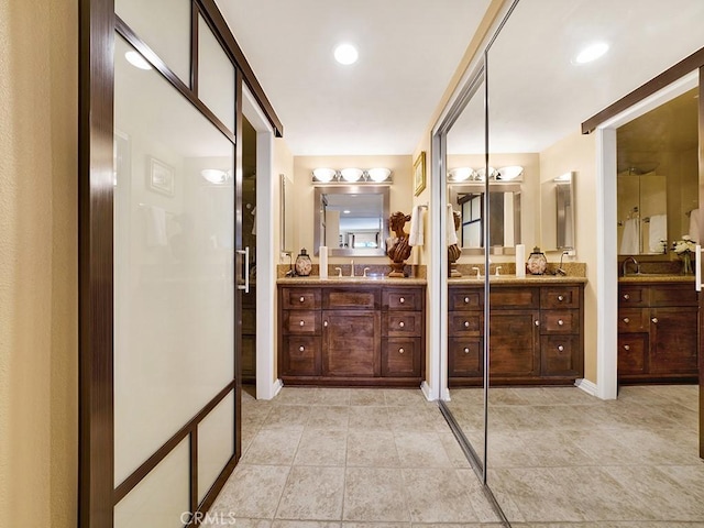 full bath with two vanities, a sink, and tile patterned floors