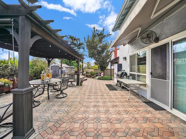 view of patio featuring an outbuilding, a storage unit, and outdoor dining area