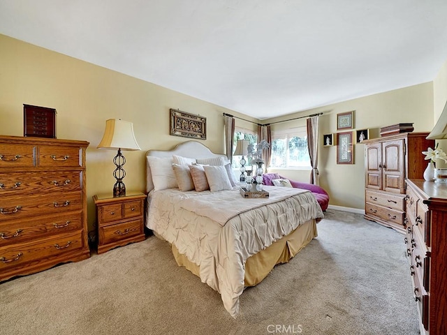 bedroom featuring light carpet and baseboards