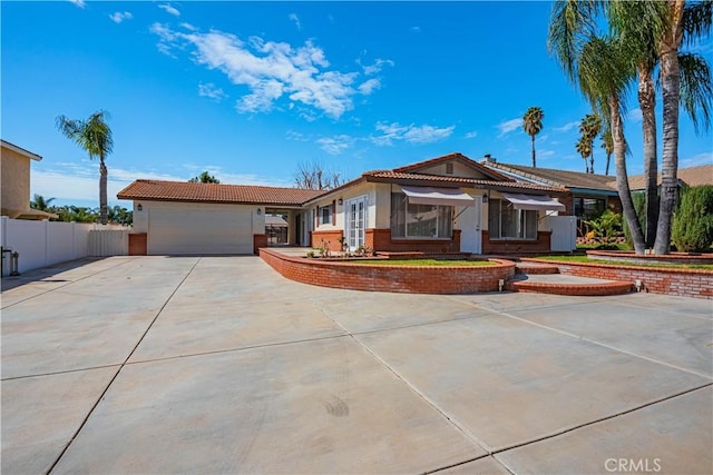 single story home featuring a garage, concrete driveway, fence, and stucco siding