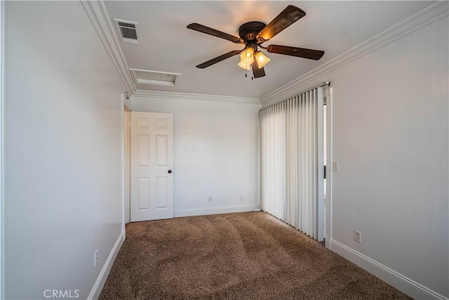 empty room featuring attic access, baseboards, visible vents, ornamental molding, and carpet