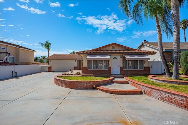 view of front of house featuring a garage, concrete driveway, a tiled roof, fence, and brick siding