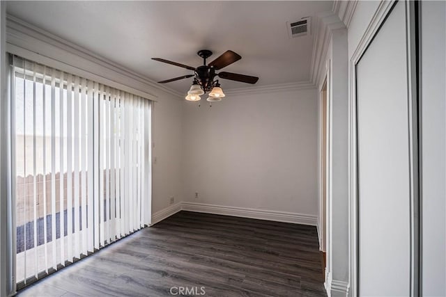 unfurnished room with baseboards, visible vents, ceiling fan, wood finished floors, and crown molding