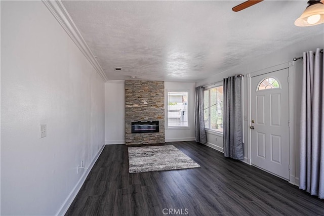 unfurnished living room with a fireplace, a ceiling fan, baseboards, ornamental molding, and dark wood-style floors