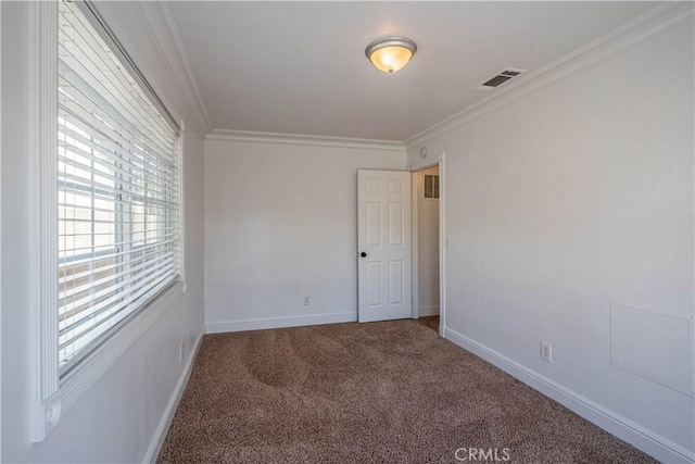 empty room featuring ornamental molding, visible vents, carpet floors, and baseboards