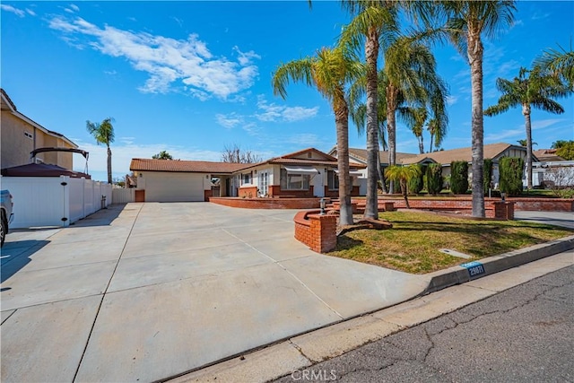 single story home with driveway, an attached garage, and fence