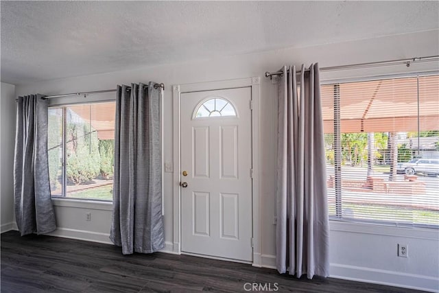 entrance foyer with dark wood-style floors, a textured ceiling, and baseboards